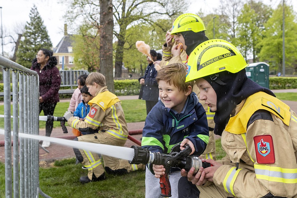 Finn Nakken mag met de brandweerspuit spuiten. Jordy Steeman van de Beverwijkse Jeugdbrandweer helpt hem een handje.