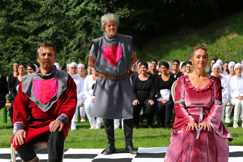 De drie hoofdrolspelers in ’Queen Arthur’ met op de achtergrond het koor.