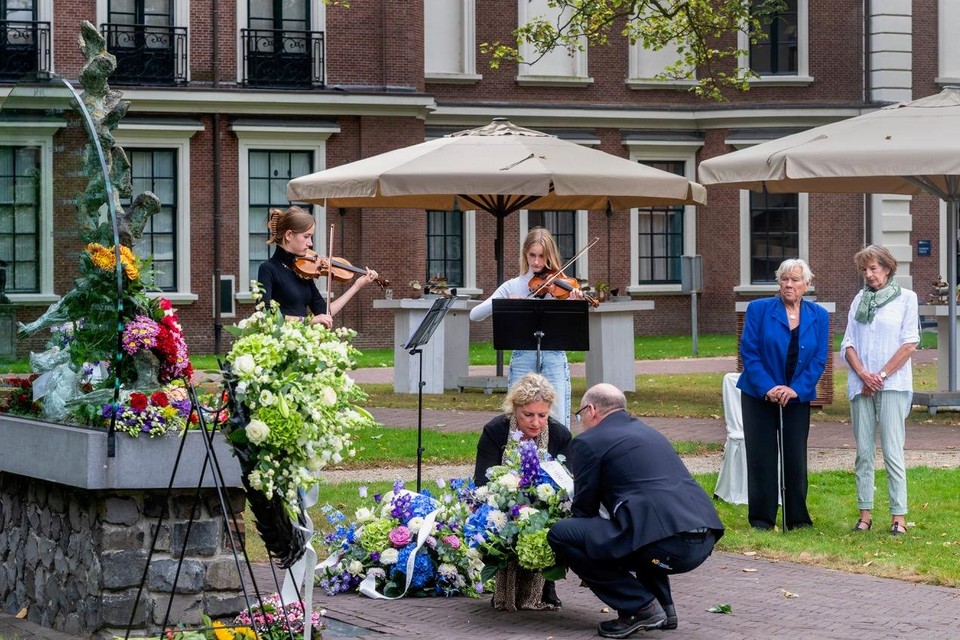 Provinciemedewerkers leggen een krans bij het monument terwijl Erin en Lute de Vos viool spelen. Rechts hun grootmoeder en mevrouw Zwager-Schriemer.