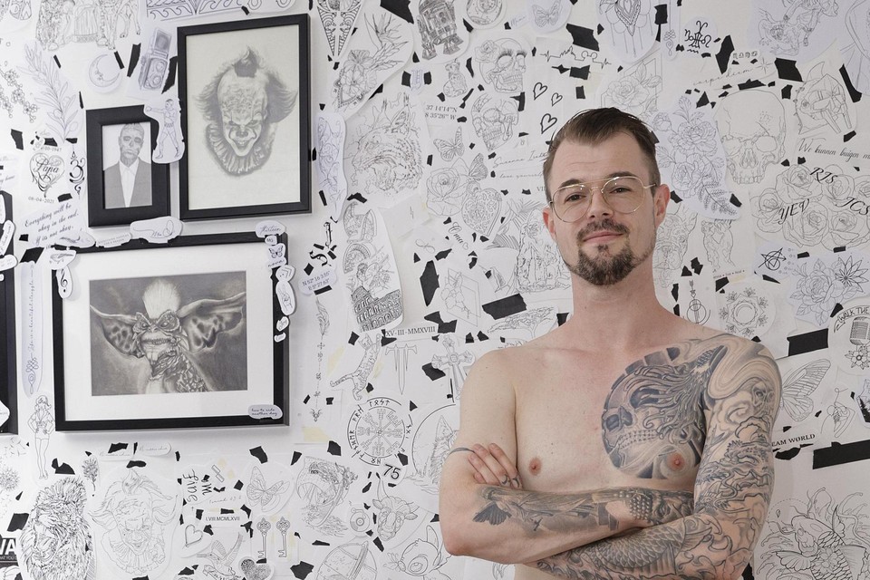 Auke Stamate met achter door hem ontworpen tatoeages.