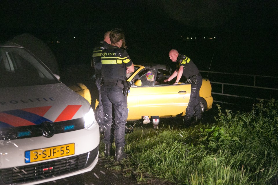 Politie checkt de inzittenden van de 'verdachte' auto in de polder bij Eemnes. foto Caspar Huurdeman