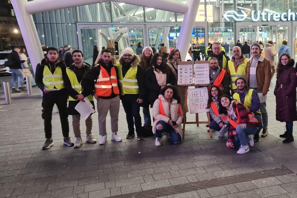 De vrijwilligers die dinsdag en woensdag geld inzamelden voor de slachtoffers in Syrië en Turkije. Hanin Ballan (met lichte jas) zit links naast het bord. Achter haar (in zwarte jas) staat Shaza Manla. Rechts naast het bord staat initiatiefnemer Tamer Alalloush uit Utrecht.