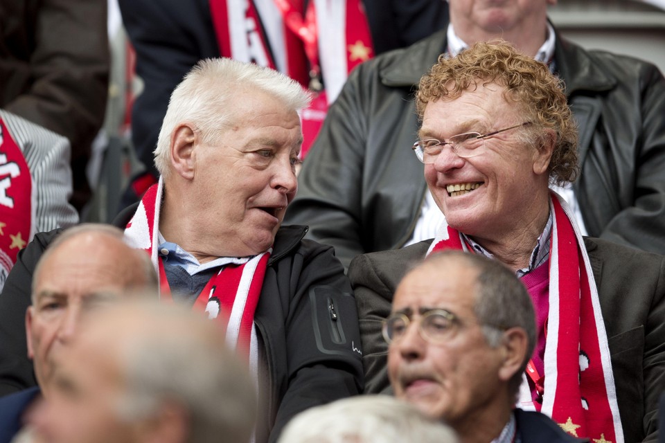 Piet Schrijvers (L) en Ruud Geels op de tribune in de zogenaamde Engelenbak bij een reünie van oud-spelers van Ajax tijdens de wedstrijd tegen FC Twente.