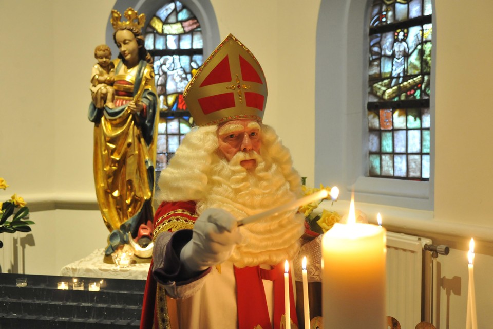 Sinterklaas steekt een kaarsje op in de Pancratiuskerk in Castricum.
