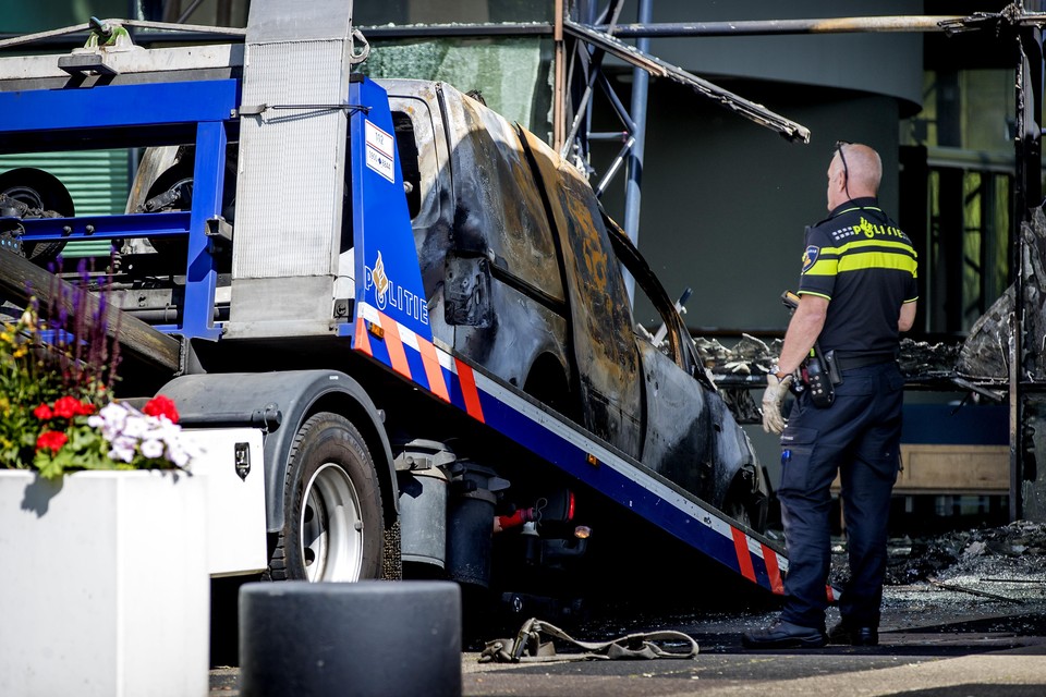 De auto waarmee de aanslag bij De Telegraaf is gepleegd wordt weggetakeld.