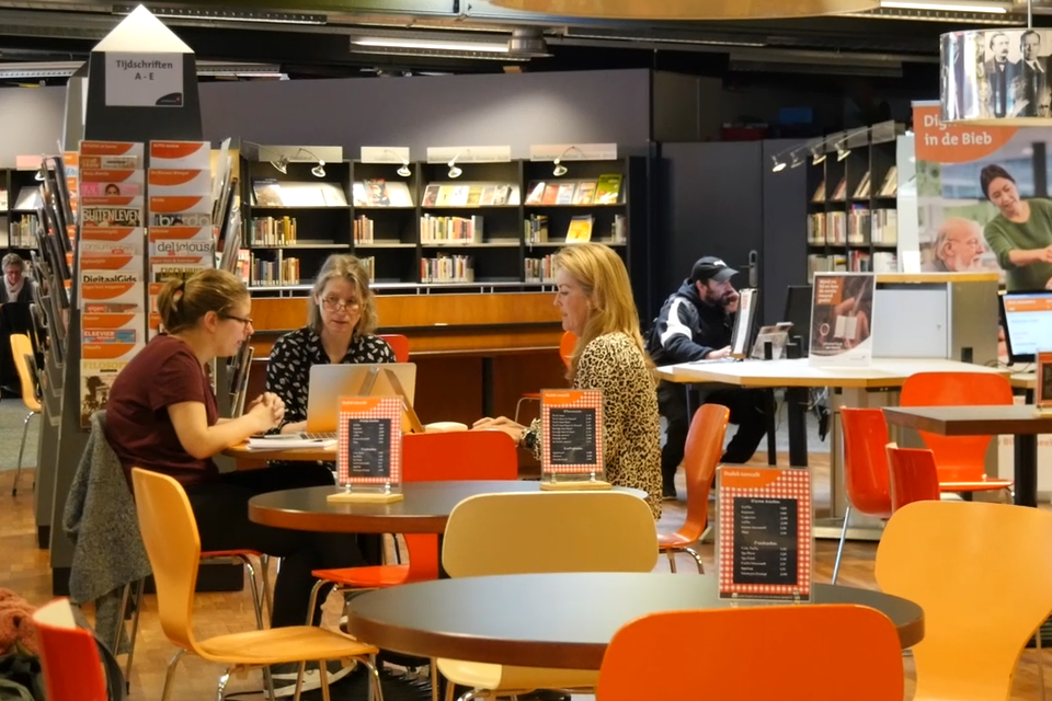 Verslaggeefsters Susanne Moerkerk, Mitzie Meijerhof en Ellen de Boer aan het werk in de bibliotheek.