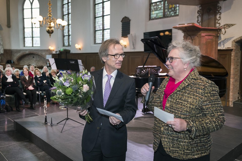 Voorzitter Jaap Verschoor krijgt de prijs uit handen van Annelies van Bruinessen.