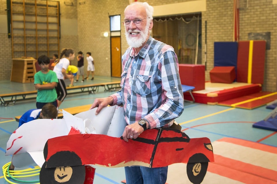 Meester Henk in de kartonnen Ferrari die kinderen voor hem hebben gemaakt.