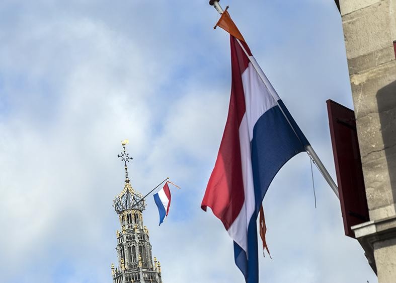 Vlaggen aan Waag en Oude Bavo.