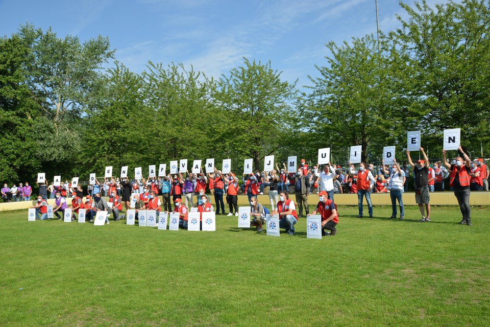 Vakbondsleden houden na afloop van de manifestatie borden omhoog die tezamen de tekst vormen ’Handen af van IJmuiden’