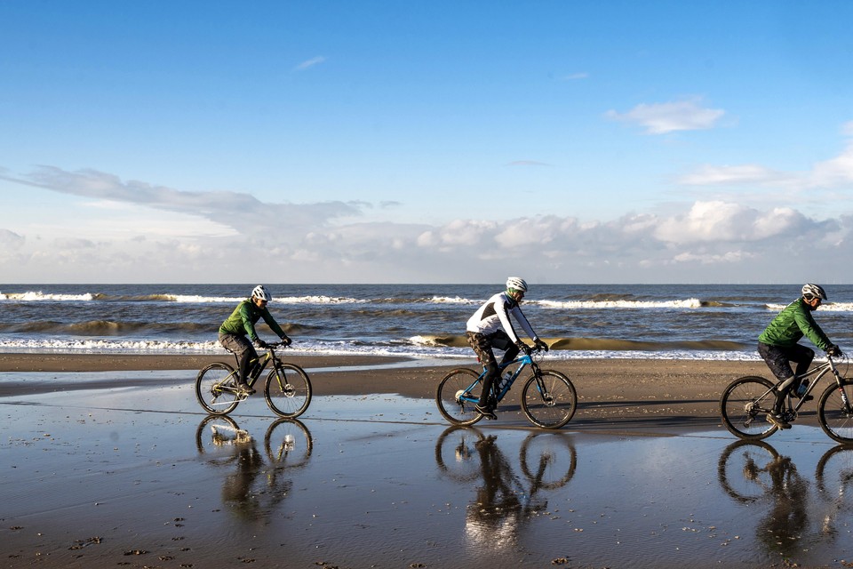 Mountainbikers (staart naar kop) Guy Dersigni, Johan van Marle en Kees Reinders op het strand van Bloemendaal.