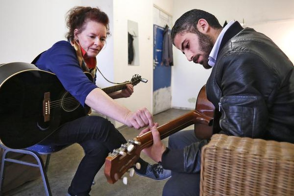 
Nola Caffey leert Qasem Ebrahim de kneepjes van de klassieke gitaar. 
