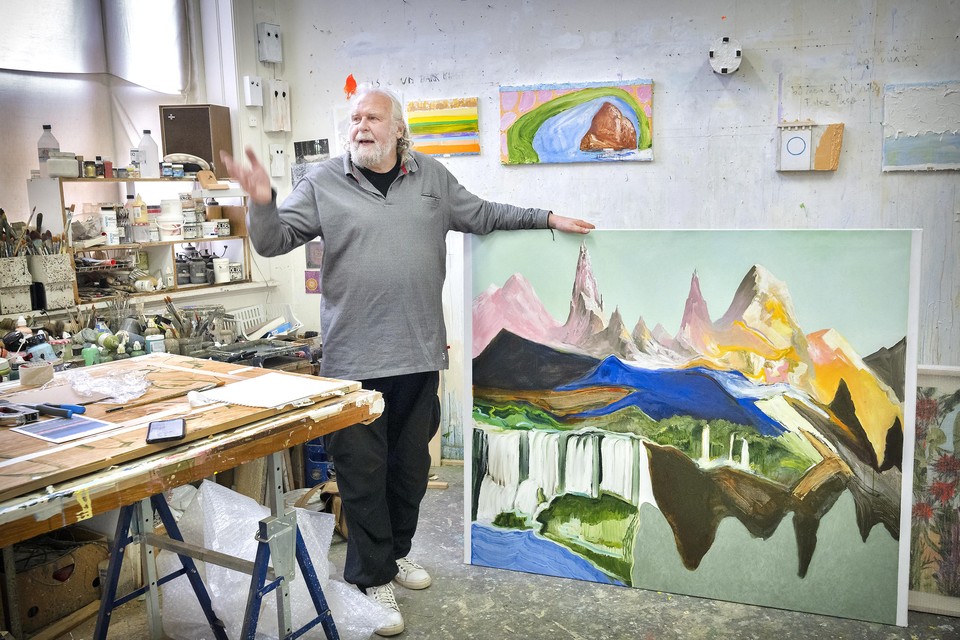 Kunstenaar Ronald Ruseler in zijn atelier met een van zijn landschappen.
