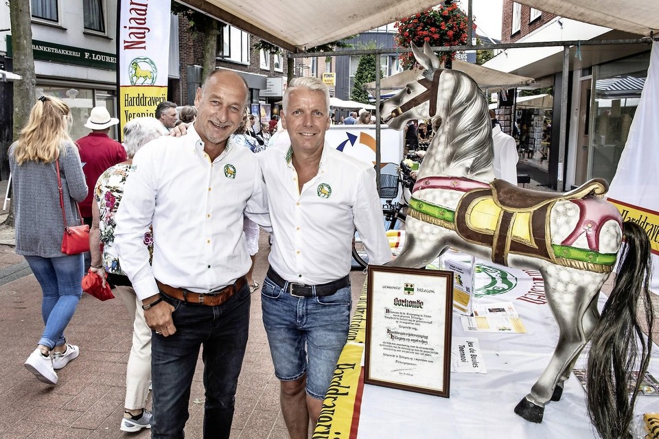 Voorzitter Frank Brouwer (rechts) met Patrick Mesman bij de stand van de harddraverijvereniging op de Hillegomse jaarmarkt.