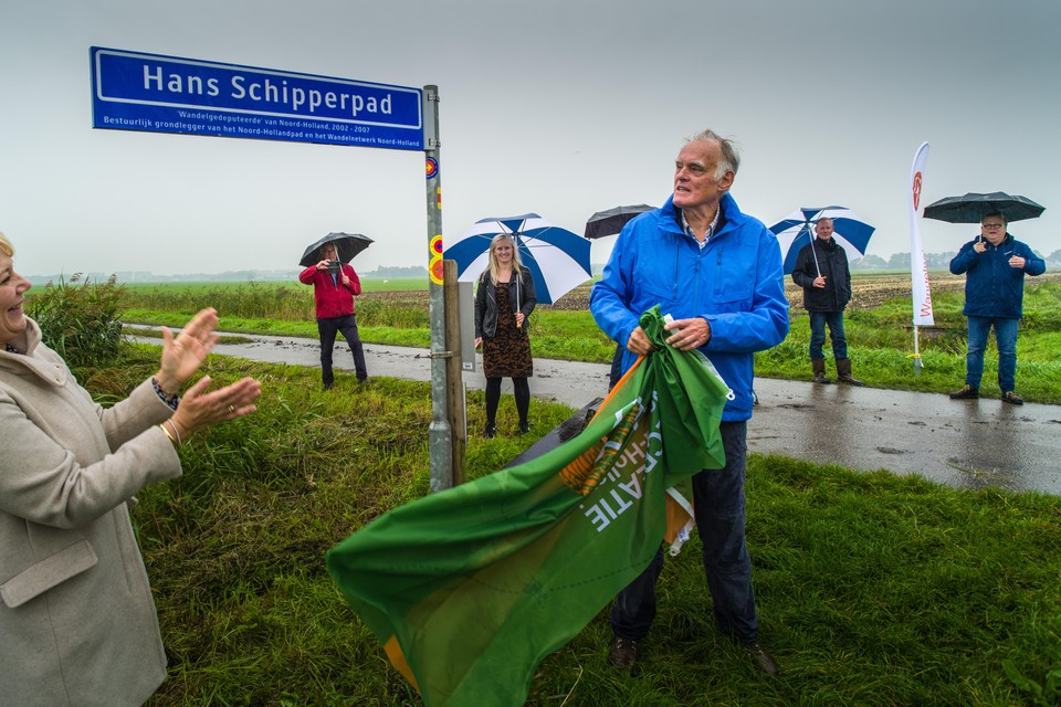 Samen met Karin van Bijsterveld, voorzitter van Recreatie Noord-Holland, trekt Hans Schipper de vlag van zijn straatnaambord.