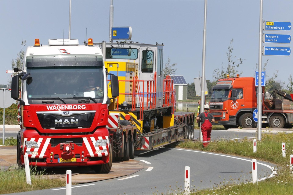 De 36 meer lange dieplader met zeventig ton zware rangeerlocomotief ’neemt’ via rijplaten de rotonde bij De Stolpen richting N9.
