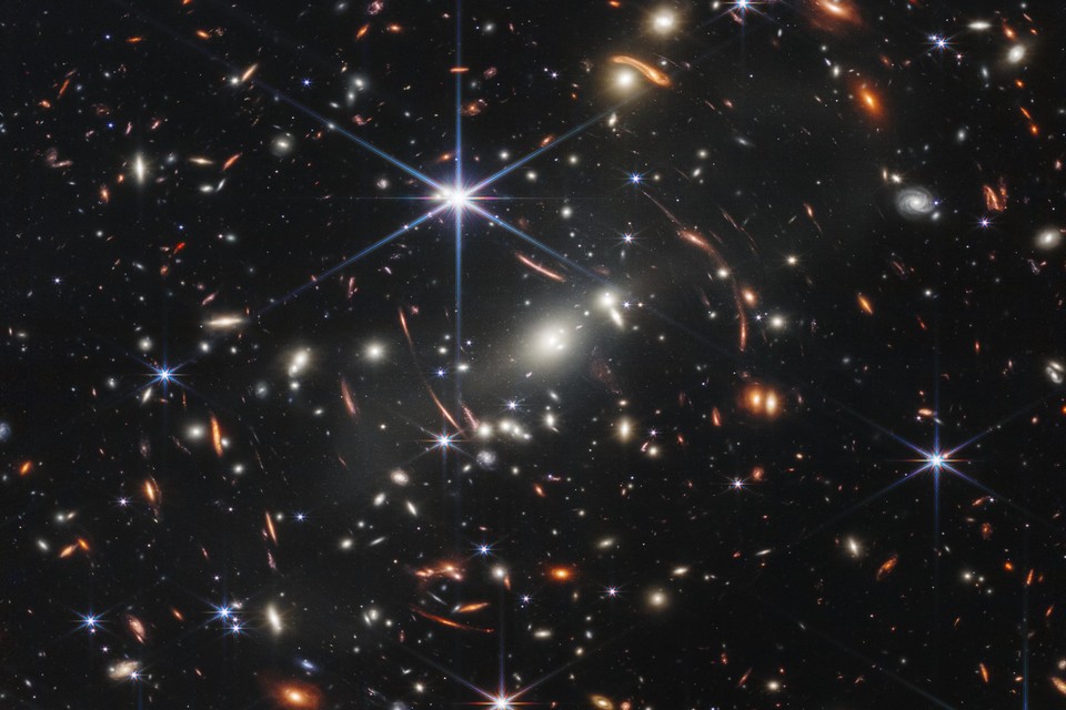 Het cluster SMACS 0723 bevat duizenden sterrenstelsels. Een ’zwaartekrachtlens’ haalt de stelsels die het verst weg staan, dichterbij.
