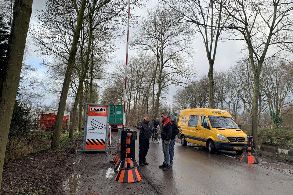 Druk bezig met het installeren van een van de twee slagbomen die een deel van de Nieuw-Loosdrechtsedijk moeten vrijwaren van sluipverkeer.