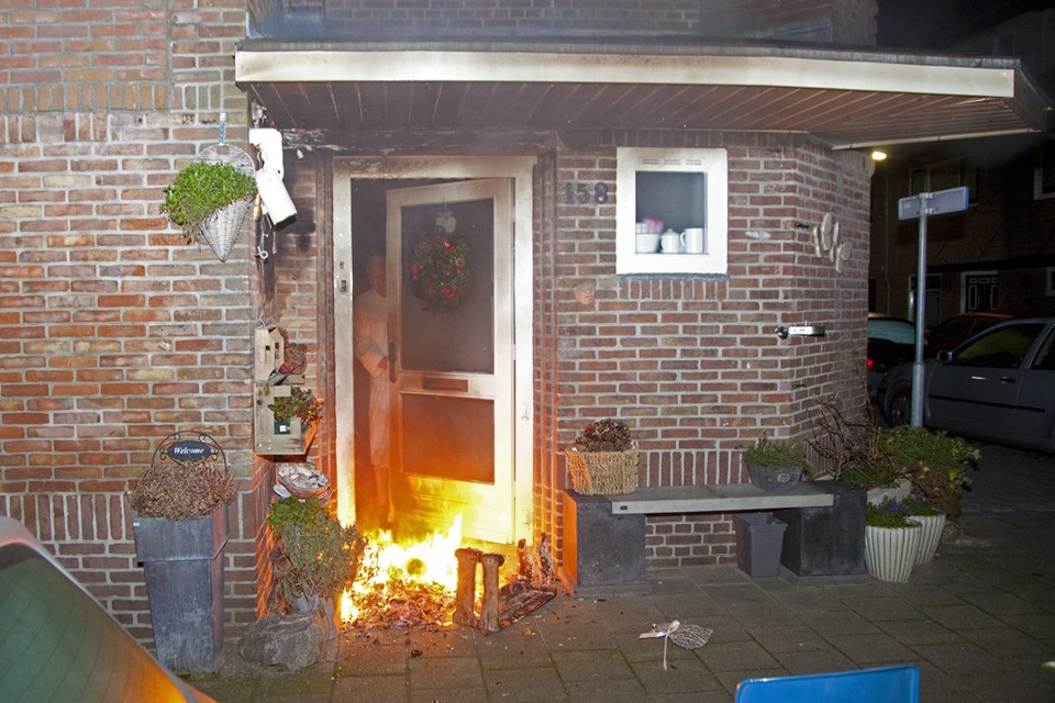 Terwijl de brandweer onderweg was, opende een bewoner de brandende deur om te kijken hoe erg het was. Foto Michel van Bergen