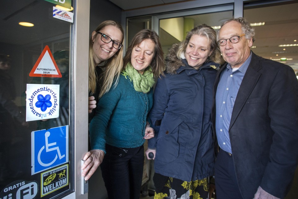 Alexia de Graaf, Nanny Luijsterburg, Marleen Sanderse en Jan Landsaat bewonderen het keurmerk ’Dementievriendelijk’ op de bibliotheekdeur in Bussum.