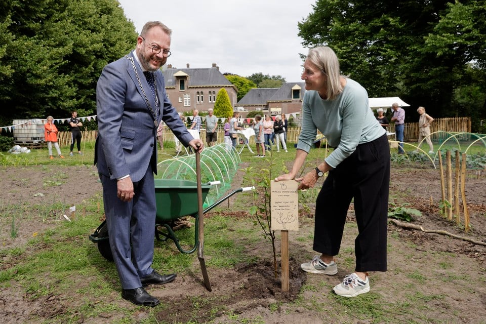 Burgemeester Roland van Benthem samen met Anna van Stuivenberg bij de net geplaatste een appelboom.