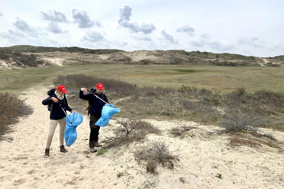 Antje Zender en Tim Rietbergen van Naturalis trekken met knijpstokken de duinen in,