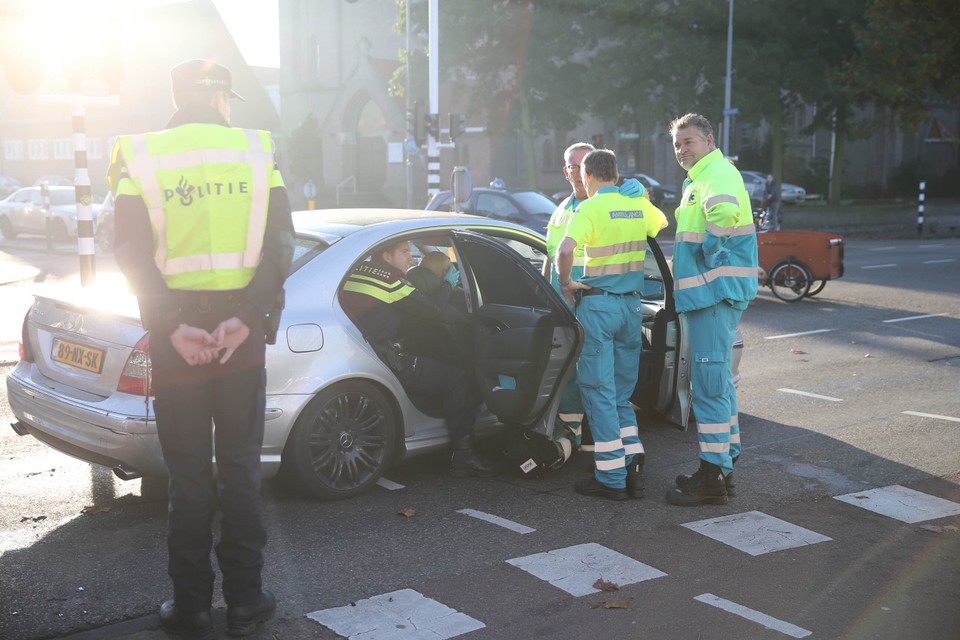 Een politieagent houdt het hoofd van een inzittende stabiel bij aanrijding Rijksstraatweg.