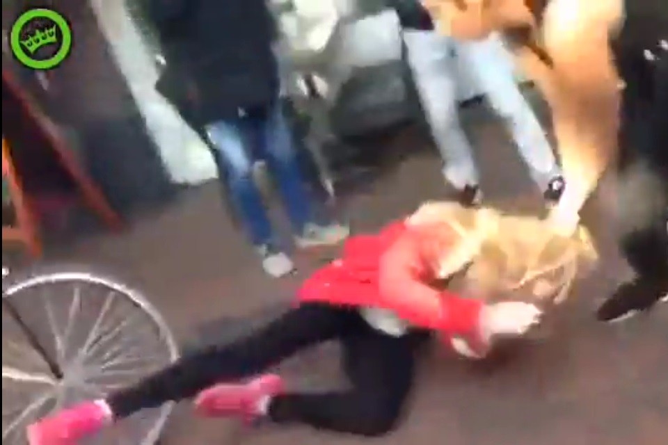 Een leerlinge van de Opmaat wordt in het centrum van Hilversum aan haar haar tegen de grond gewerkt door een ander meisje.  still uit filmpje op Geenstijl.nl