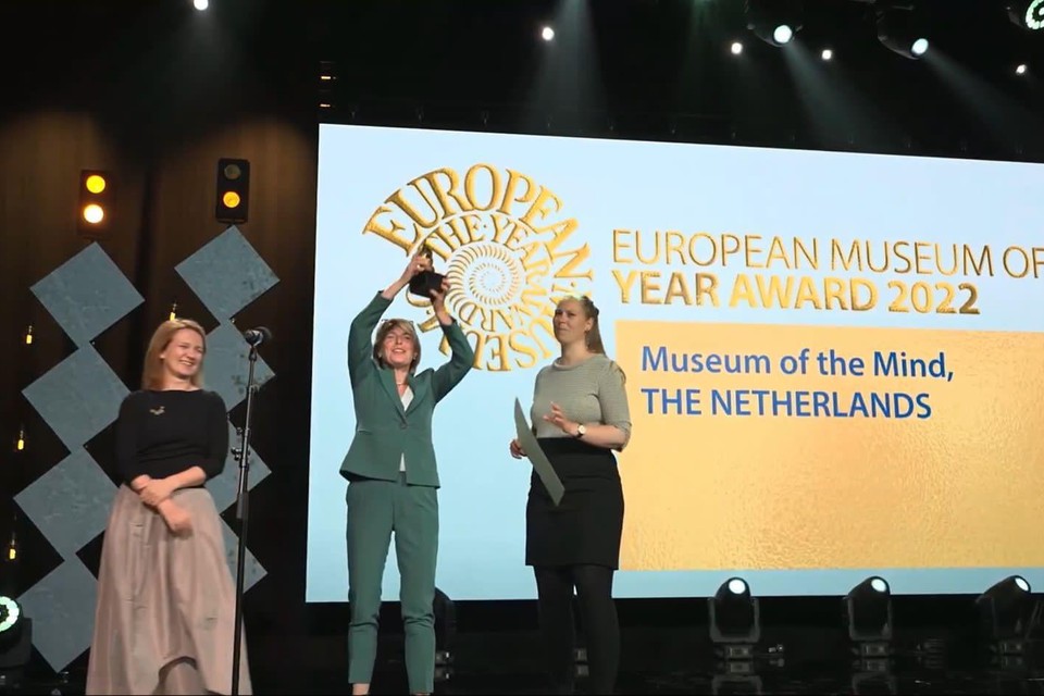 Het Museum van de Geest is de winnaar van de European Museum of the Year Award 2022. Carine Neefjes, hoofd publiek en onderwijs, houdt de trofee omhoog.