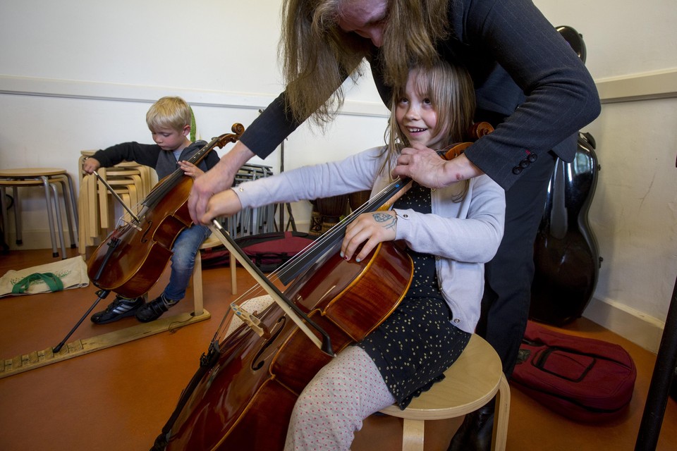 De 7-jarige Aurelia mag de eerste streken zetten op een cello.