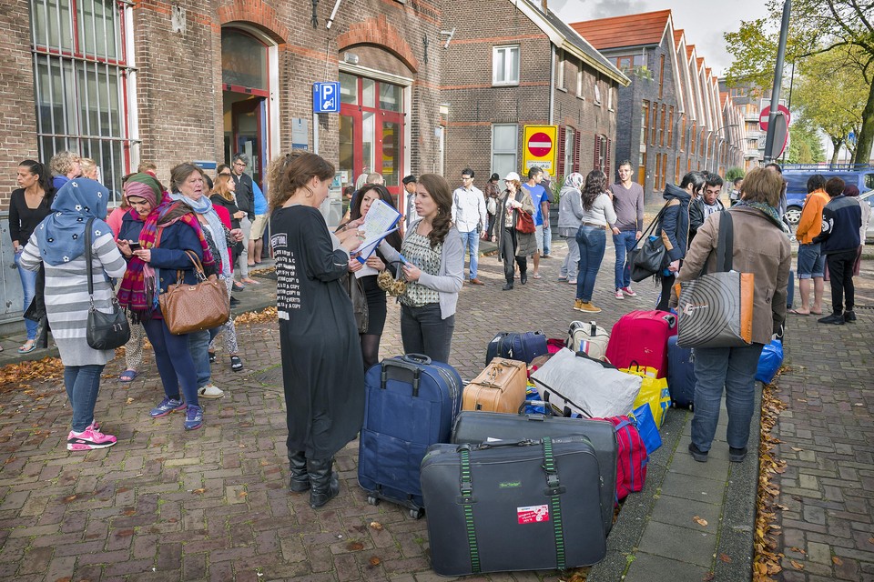 Statushouders met koffers op de stoep in Haarlem.