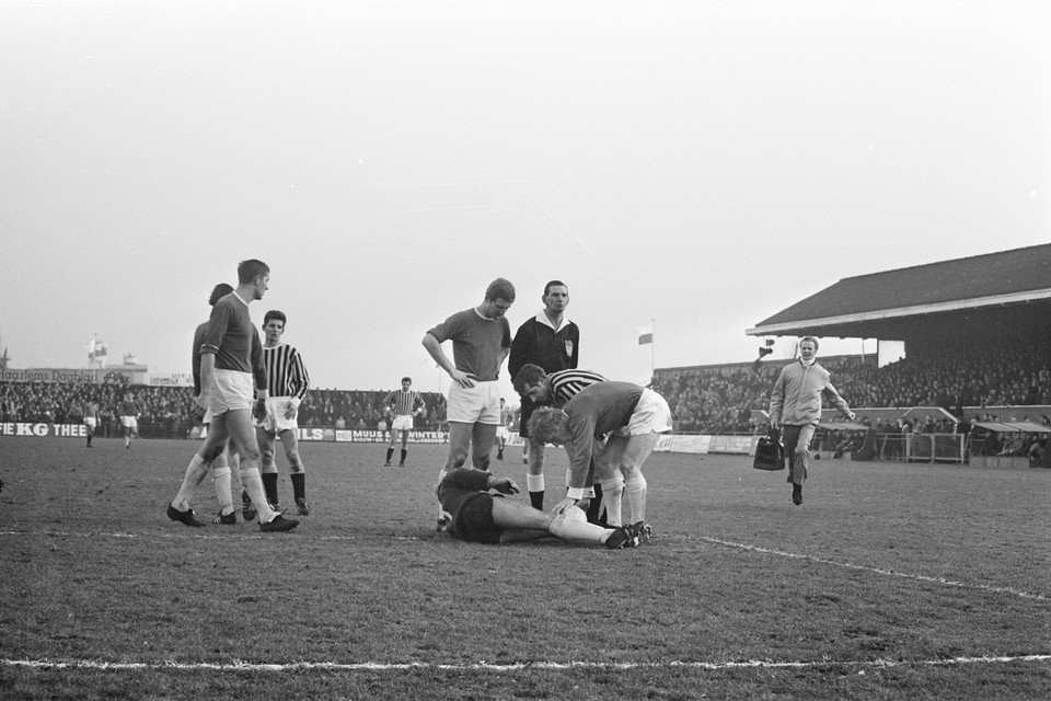 RCH tegen Vitesse op 5 januari 1969 in het volgepakte stadionnetje aan de Sportparklaan. Een verzorger rent het veld in om doelman Siem Bes te behandelen.