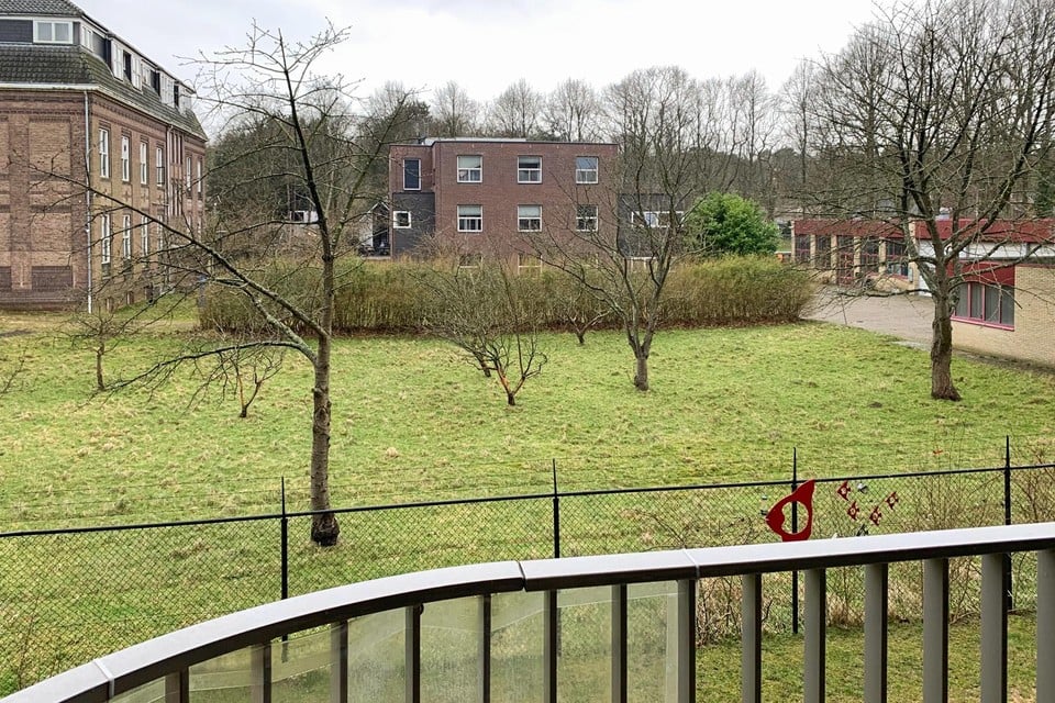 De boomgaard waar de generatiewoningen komen, gezien vanaf de eerste verdieping van een appartement in Nieuw Velserduin.