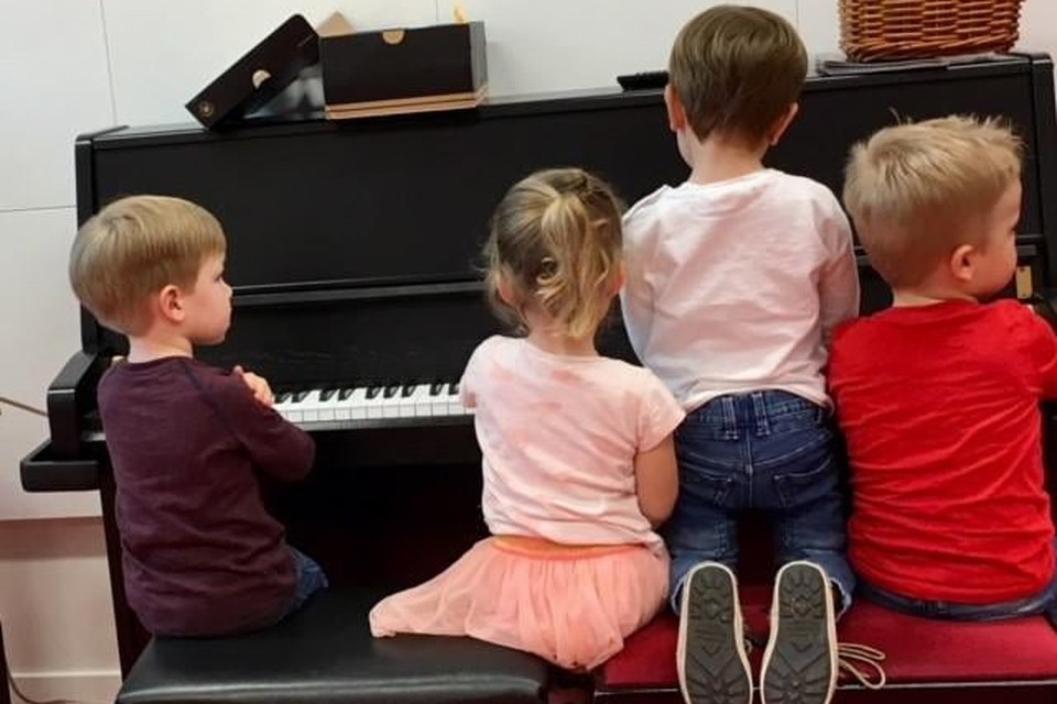 Kinderen laten een deuntje horen op de piano.
