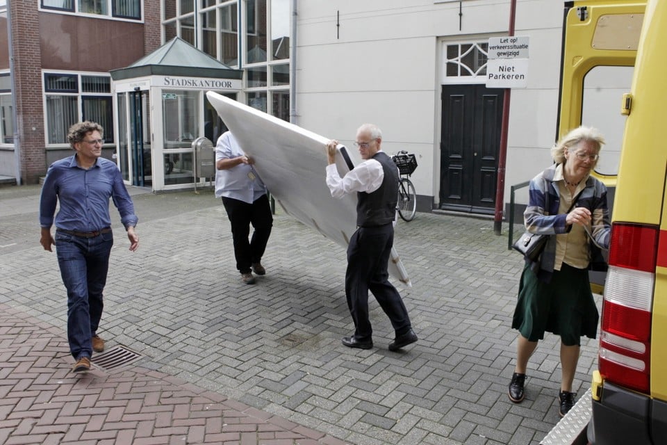 Peter Eijking (links) en Aukje Zondergeld begeleiden het inladen van het schilderij. Foto: Stduio Kastermans