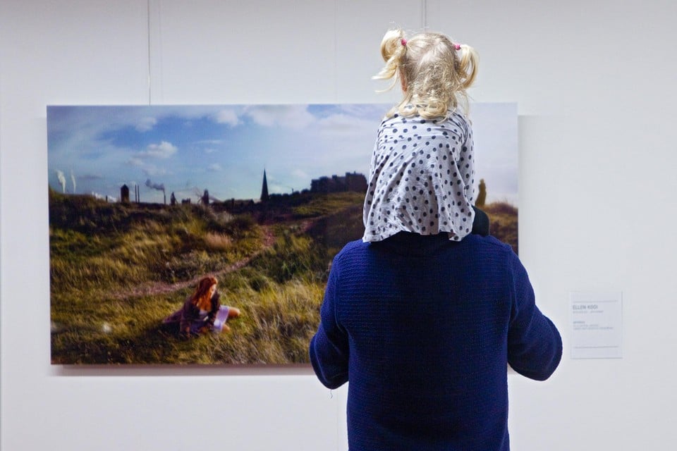 Een jonge bezoekster ’Grafietregen’ kijkt naar werk van Ellen Kooi.
