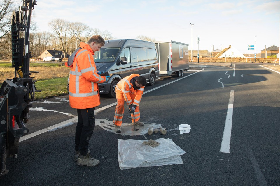 In het asfalt van de oprit naar de A1 worden boringen gedaan.