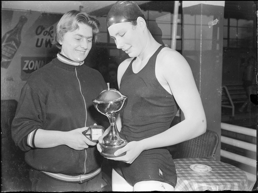 Een prijswinnende zwemster en haar trainster? Wie zijn het en waar en wanneer is deze foto gemaakt?