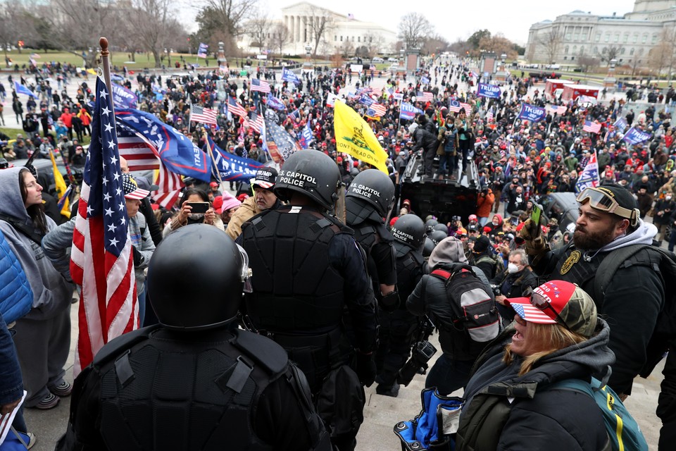 Leden van de Capitol Police banen zich een weg door de haag van demonstranten bij het Capitool.