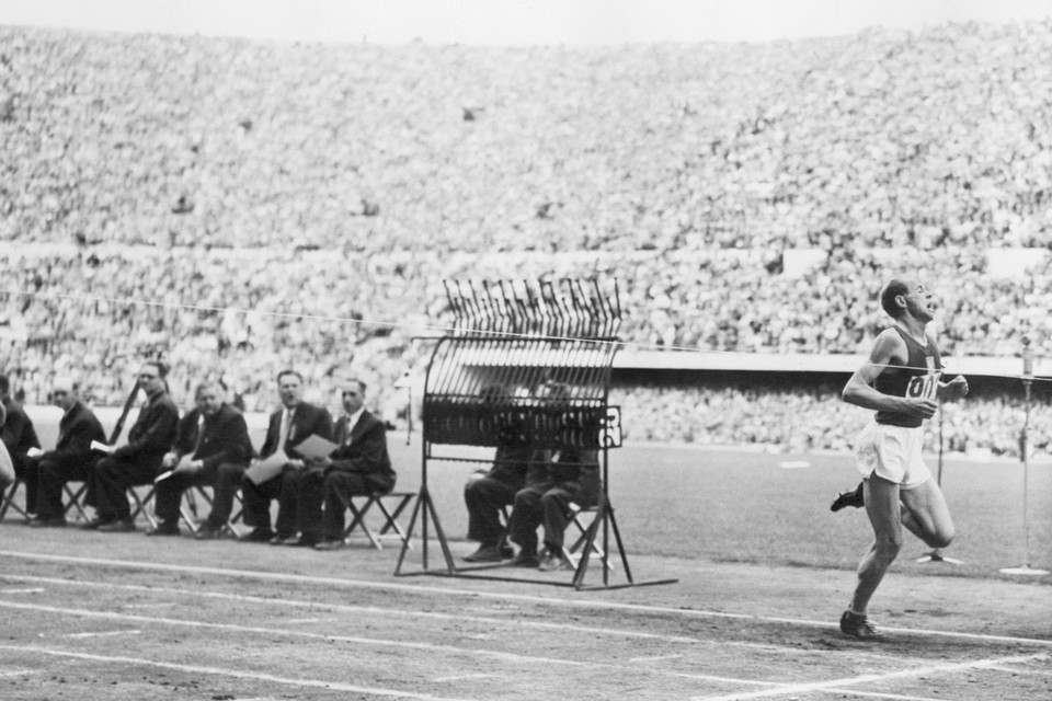 Emil Zatopek komt als eerste over de finish tijdens de 5.000 meter op de Spelen van 1952 in Helsinki.
