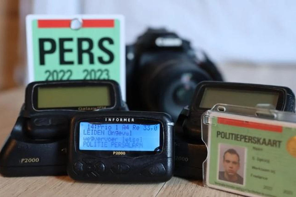 Piepers, perskaart en camera, het onmisbare gereedschap van de 112-fotograaf.