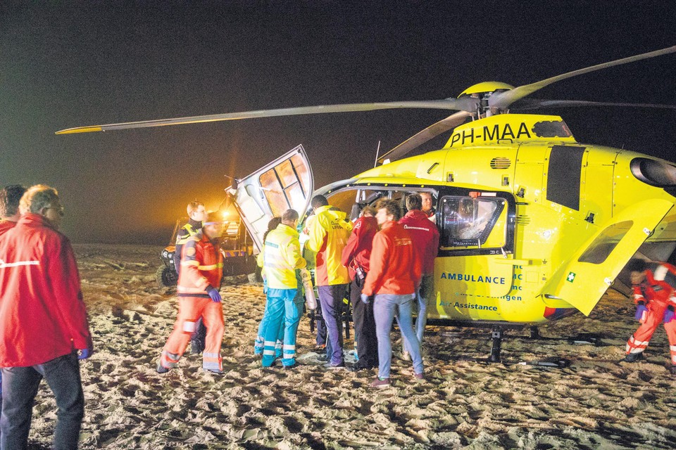 Een traumaheli landt op het strand om het slachtoffer naar het ziekenhuis te vervoeren.
