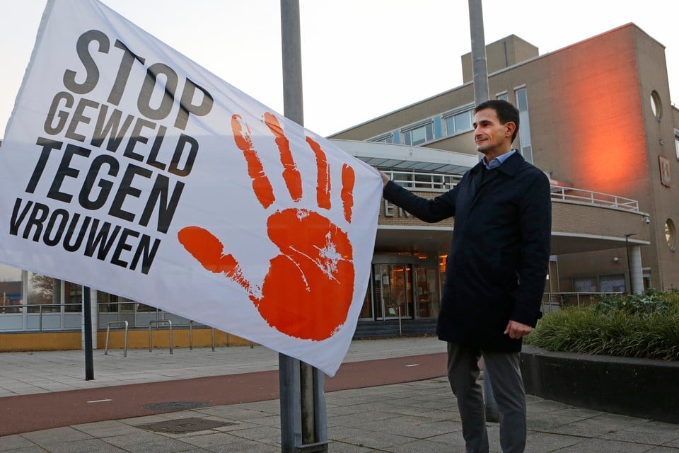 Wethouder Maarten Hoelscher hijst de OrangeTheWorld-vlag bij het gemeentehuis van Huizen.