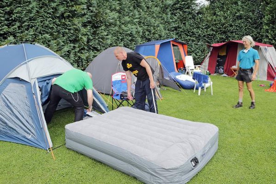 
Campinggasten maken hun tent klaar voor komend weekend. Eigenaar Wim Steman kijkt toe.

