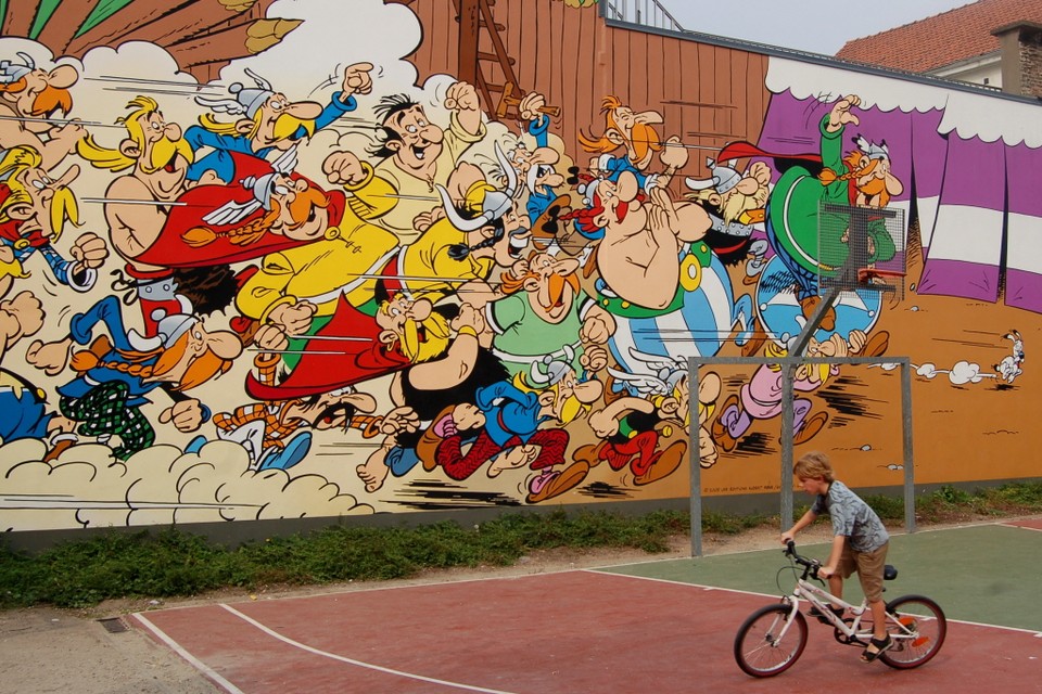 Asterix en Obelix stormen van de muur af. 