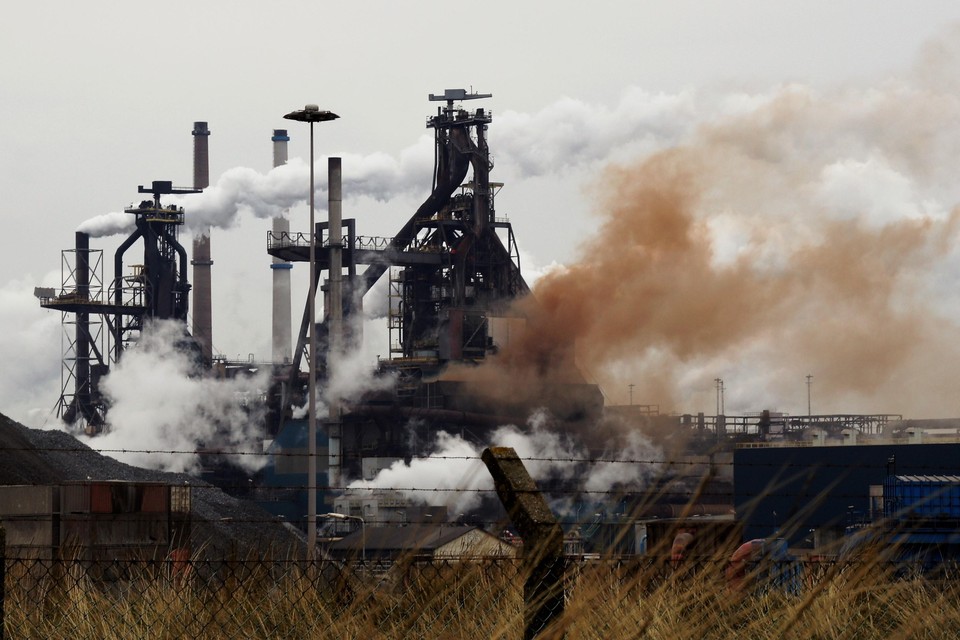 Een bruine stofwolk ontsnapt uit een hoogoven bij Tata Steel.