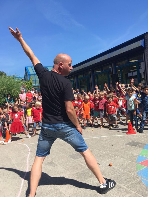 Sytse Verstraten geeft een workshop. Als hij zijn linkerarm opsteekt, steken de kinderen hun rechterarm in de lucht.