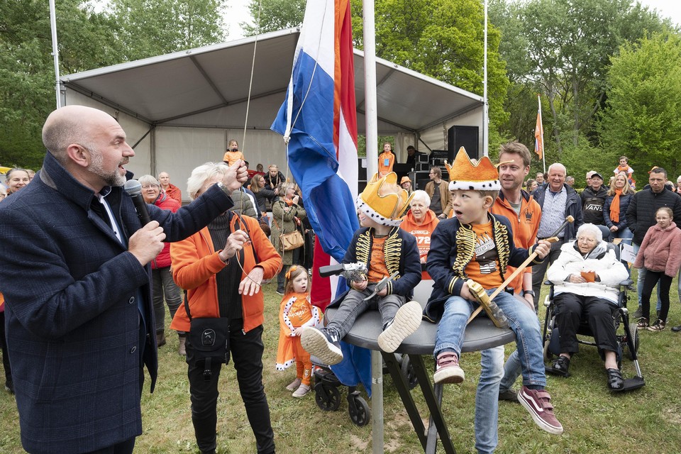 Vlnr.: Wethouder Jeroen Verwoort en Christa van Dam hijsen de vlag. De ’prinsjes’kijken toe.