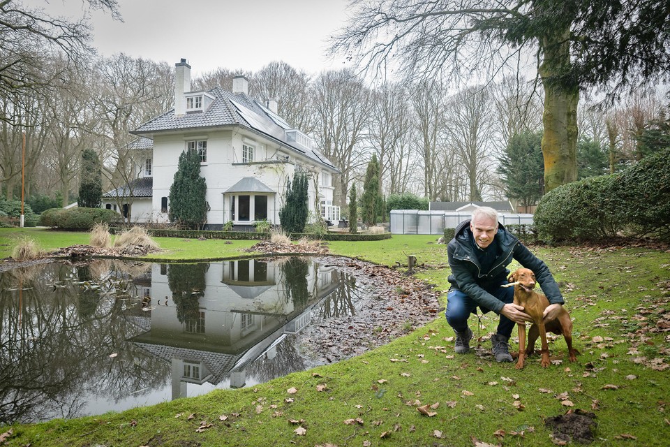 Peter Kales met één van zijn honden voor zijn villa.