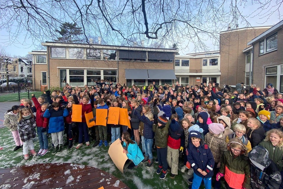 Leerlingen van de Bussumse Koningin Emmaschool tonen op het schoolplein het resultaat van hun acties.